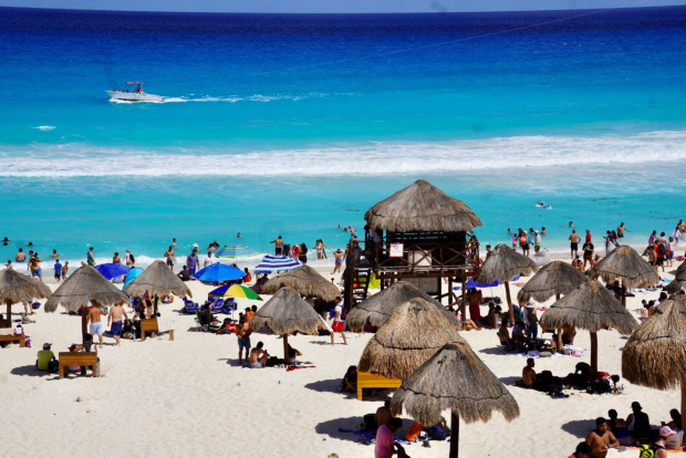Turistas disfrutando de sus vacaciones en Cancún.