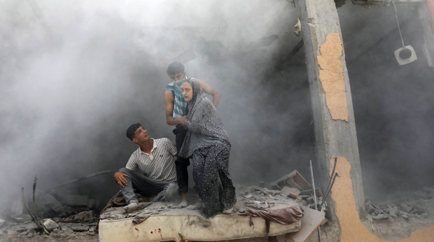 Palestinos salen de una vivienda bombardeada por Israel, en Deir Al-Balah, en el centro de Gaza.