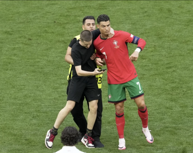 Cristiano Ronaldo es interceptado por un aficionado en el partido de Portugal vs Turquía
