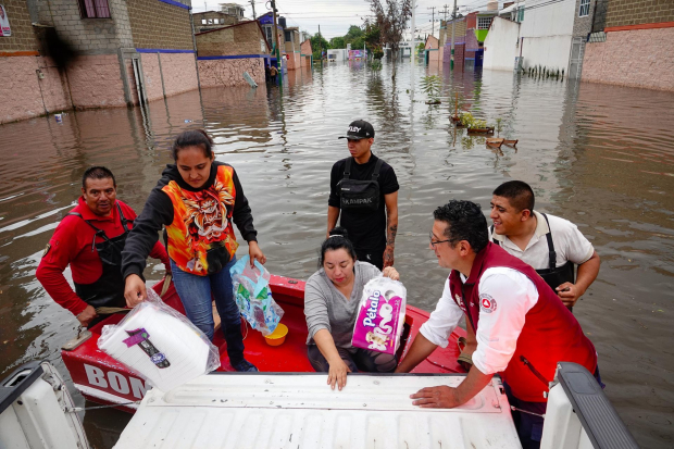 Vecinos son apoyados a salir, debido a las fuertes lluvias en Cuautitlán.