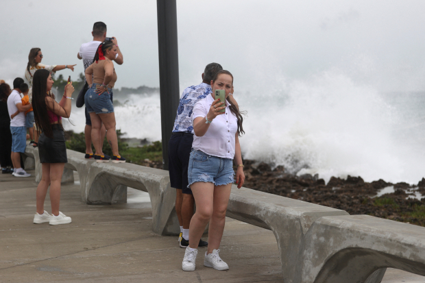 Pese al riesgo por fuertes marejadas, ciudadanos aprovechan para tomarse fotos ante olas altas.
