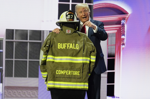 El exmandatario honra al bombero asesinado en Pensilvania, Corey Compertore, con su uniforme en el escenario de la Convención Republicana, ayer.