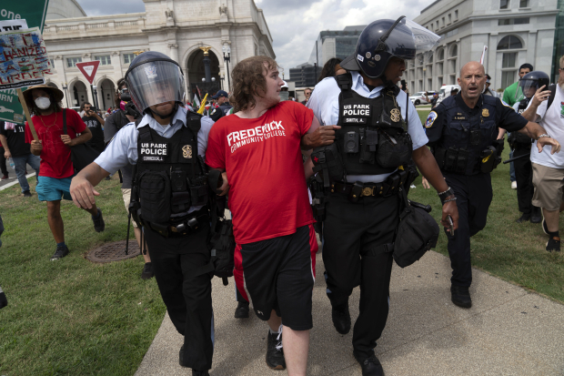 Policías arrestan a un joven manifestante afuera del Congreso.