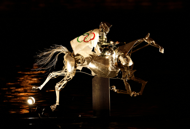 Se hizo referencia a Juana de Arco montando a caballo mientras llevaba la bandera de los Juegos Olímpicos.