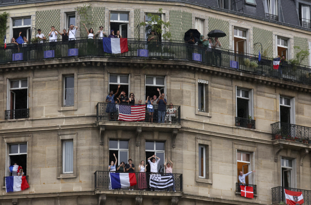 Algunos aficionados observan el recorrido de los atletas desde los balcones en el río Sena, ayer.