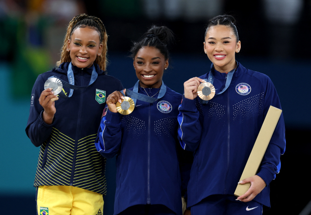 Simone Biles (centro) al lado de Rebeca Andrade (izq.)  y Sunisa Lee (der.).