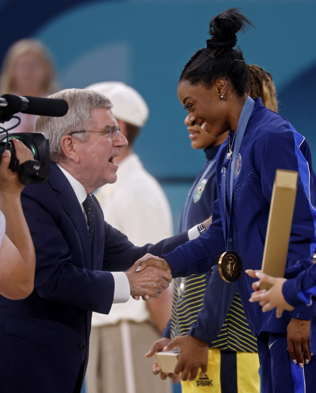 El presidente del COI, Thomas Bach, felicita a  la gimnasta estadounidense, ayer.