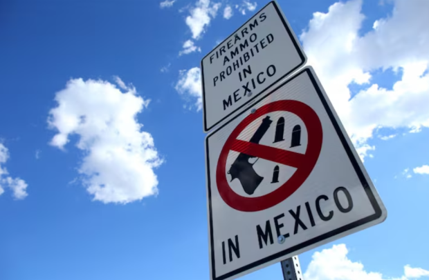 Un cartel que advierte a los conductores que las armas de fuego y las municiones están prohibidas en México se ve en la frontera entre Estados Unidos y México en Nogales, Arizona, Estados Unidos.