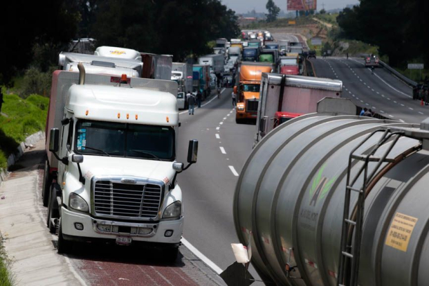 Familias han dejado sus vehículos o transportes para continuar sus caminos, ayer.