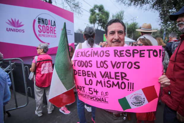 Personas colocan cartulinas tras la marcha contra la sobrerrepresentación.