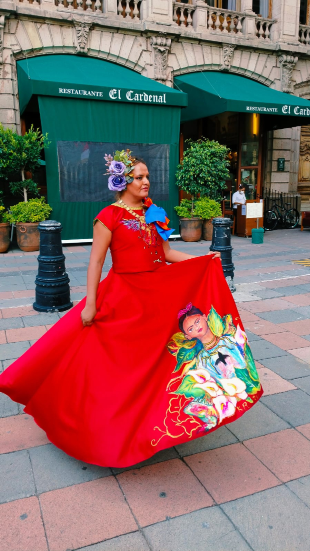 Carla Rey, artista muxe, posa con un vestido rojo frente al restaurante El Cardenal.