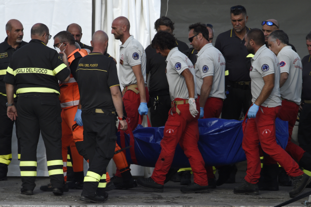 Bomberos italianos llevan el cuerpo de una de las víctimas del naufragio, ayer.