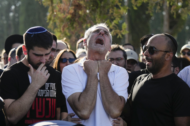 Yigal Sarusi, padre de uno de los cautivos asesinados, llora durante el funeral para despedir a su hijo Almog Sarusi.