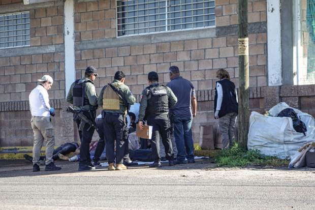 Policías y peritos revisan el lugar donde fueron localizados los cuerpos de 5 hombres baleados en Culiacán, el pasado domingo.