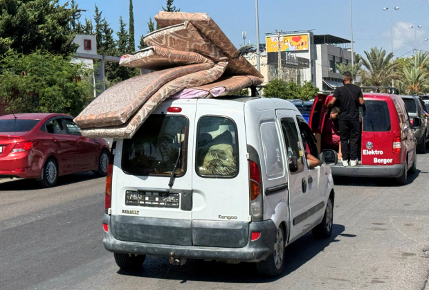 Con colchones y las pocas pertenencias que lograron subir a sus autos familias buscan otro hogar.