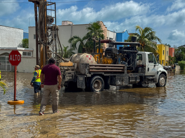 Trabajadores realizan labores de limpieza en Cancún, bajo la supervisión de la gobernadora Mara Lezama, después del impacto de "Helene" en la región.