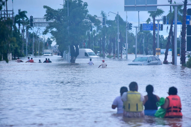 Habitantes caminan entre las calles inundadas, buscando alimentos o en busca desalojar la zona.