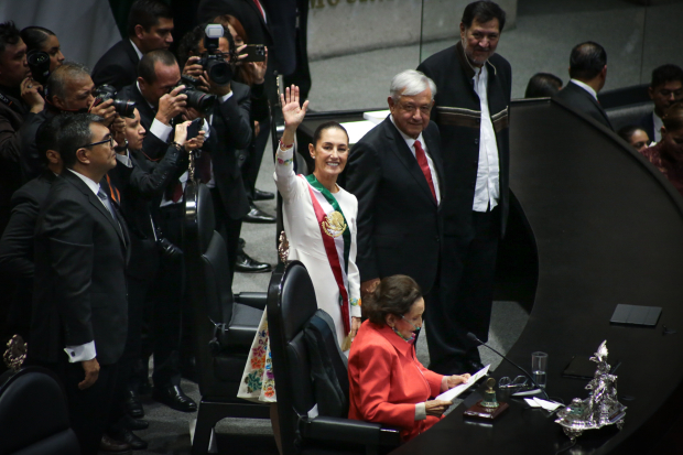 La Presidenta Claudia Sheinbaum saluda tras haber rendido protesta en el cargo, ayer, en San Lázaro; la observan Andrés Manuel López Obrador y Gerardo Fernández Noroña.