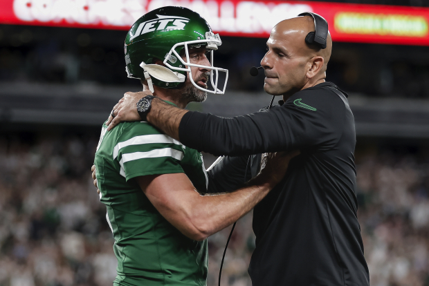 El quarterback Aaron Rodgers (8) y el entrenador Robert Saleh de los Jets durante el primer cuarto de un partido de la NFL contra los Patriots