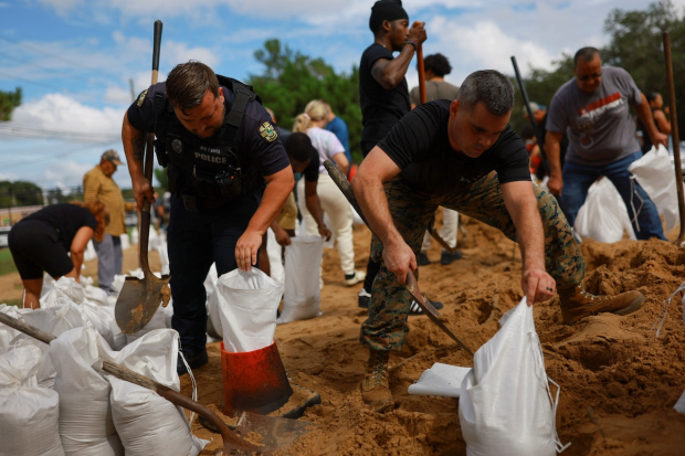 Personal de emergencias y voluntarios ayudan a recolectar arena que sirve para proteger viviendas y negocios en las costas.