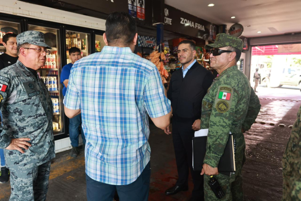 El titular de la SSPC dialoga con habitantes de Culiacán en una zona comercial, ayer.