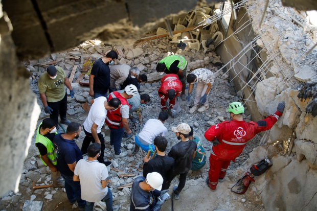 Rescatistas y habitantes de la zona inspeccionan el lugar donde cayó una bomba israelí, ayer en Líbano.