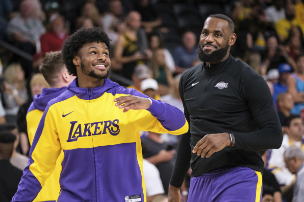 El base de los Lakers de Los Ángeles Bronny James y el alero LeBron James calientan antes de un encuentro de pretemporada ante los Suns de Phoenix