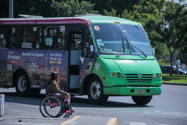 La activista espera que pase un microbús para cruzar calle.