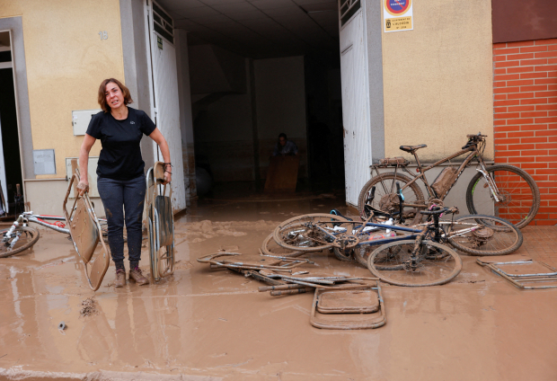 Mujer saca sillas plegables, tras inundacones