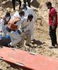 Voluntarios ayudan a recuperar cuerpos en una fosa hallada en el hospital Al-Nasser.