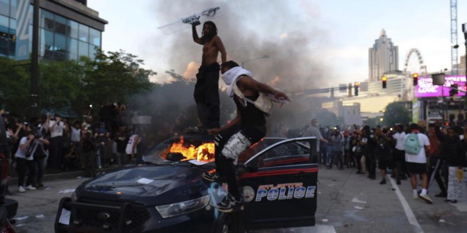 Manifestantes destrozan patrullas en Atlanta, ayer.