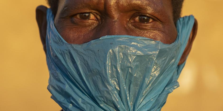 Un hombre se cubre el rostro con una bolsa de plástico en Katlehong, al este de Johannesburgo, Sudáfrica el 6 de mayo del 2020.