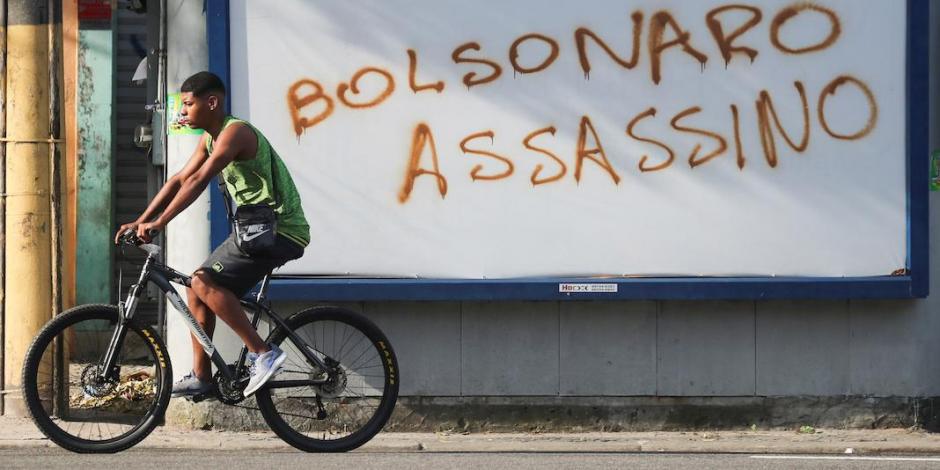 Un hombre pasa junto a un graffiti, “Bolsonaro asesino”, en Río de Janeiro, ayer.