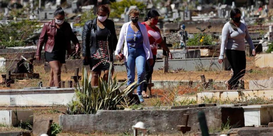 Familiares de una víctima del coronavirus acuden al entierro en Brasilia, ayer.