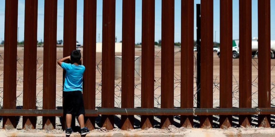 Un niño observa a través del muro fronterizo, en la frontera México-EU, en 2019.