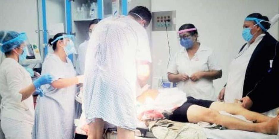 Aún en bata de hospital el ortopedista ayuda a compañeros médicos para detener una hemorragia.