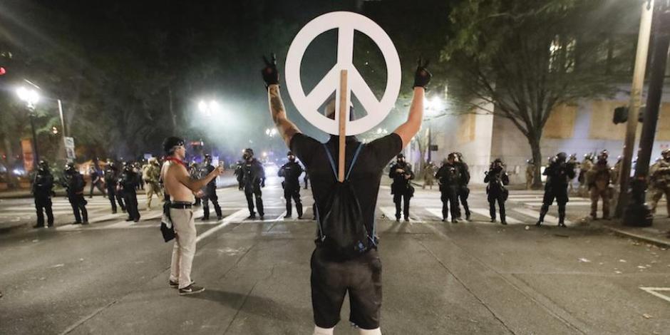 Un manifestante con un símbolo de la paz, durante la jornada de protestas, ayer.