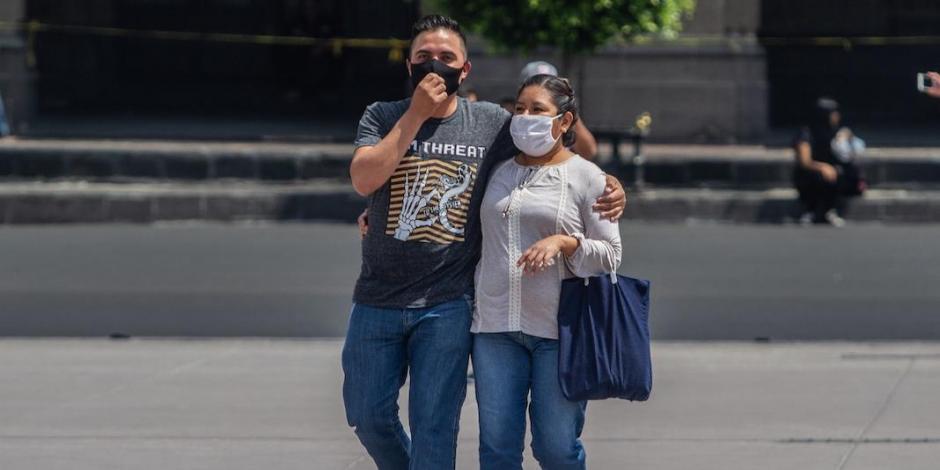 Una pareja pasea con cubrebocas por el Zócalo capitalino, en julio pasado.