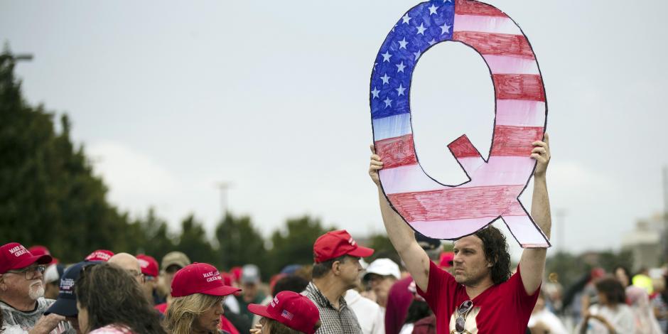 Una persona sostiene en lo alto una Q, en un acto de campaña del presidente Donald Trump, el 2 de agosto de 2018.