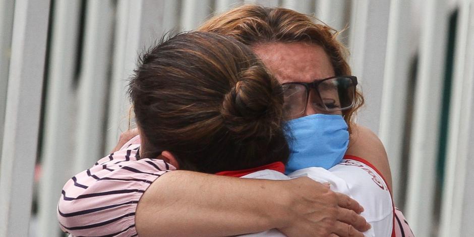 Dos mujeres se abrazan afuera de un hospital de la Ciudad de México.