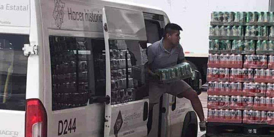 Un hombre es captado cuando descarga paquetes de cerveza de una camioneta del DIF-Puebla.
