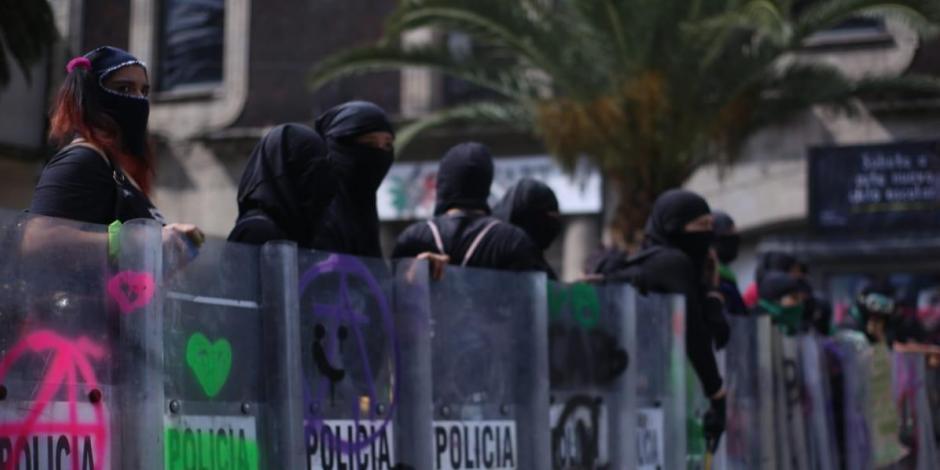 Mujeres portan escudos antimotines que le quitaron a elementos de la SSC-CDMX durante enfrentamientos.