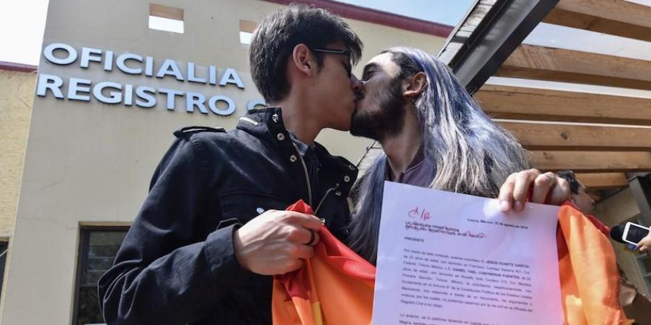 Recién casados muestran su acta al salir del registro civil, en Toluca.