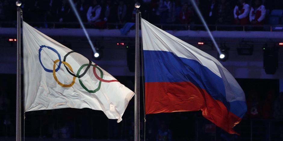 La bandera de Rusia ondea al lado de la bandera olímpica durante la ceremonia de clausura de los Juegos Olímpicos de Invierno 2014 en Sochi.
