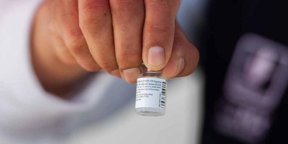 Un médico muestra la vacuna que llegó al país para arrancar el plan de vacunación.