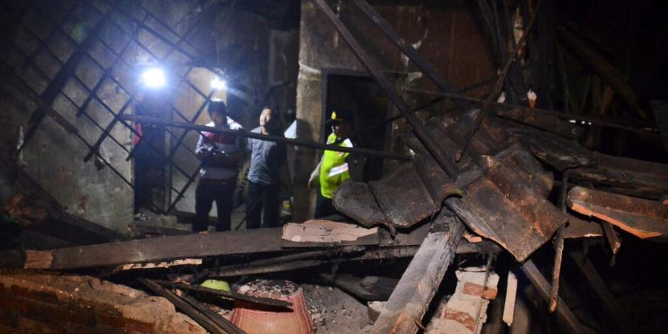 Un oficial indonesio revisa una casa que se derrumbó a causa del sismo.