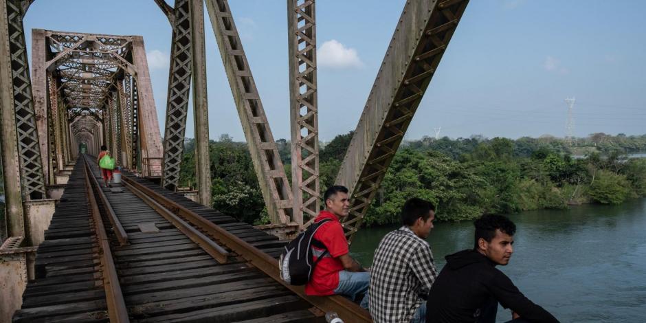Un grupo de migrantes hondureños continua su camino rumbo al norte del país sobre las vías del tren en el puente San Manuel.