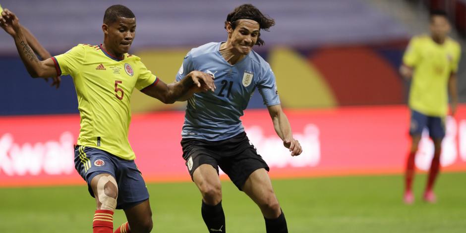 Wilmar Barrios y Edinson Cavani luchan por el balón en el choque entre Uruguay y Colombia en Brasilia.