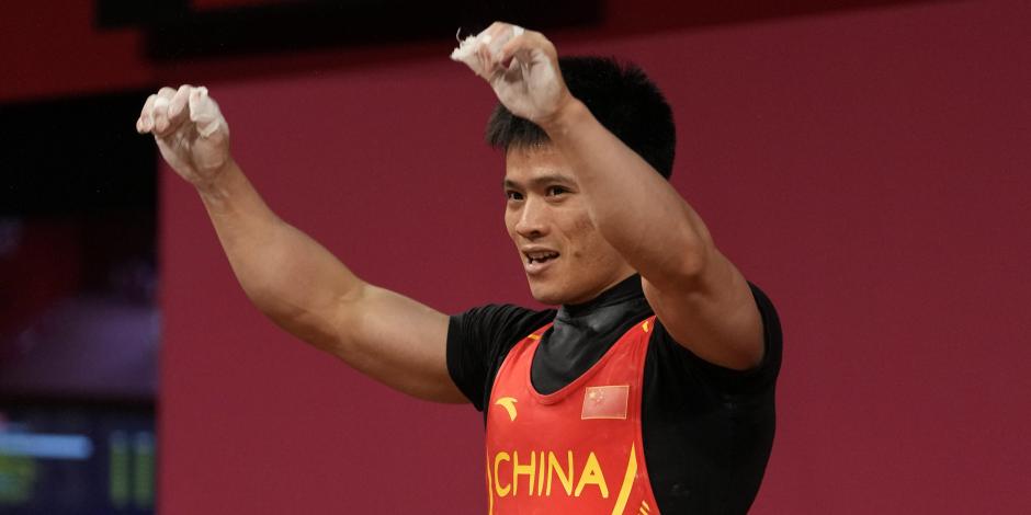 El chino Li Fabin celebra después de su medalla conseguida en halterofilia en Tokio 2020.