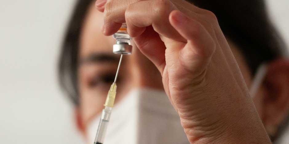 Una enfermera llena la jeringa con el biológico de la vacuna contra el COVID-19